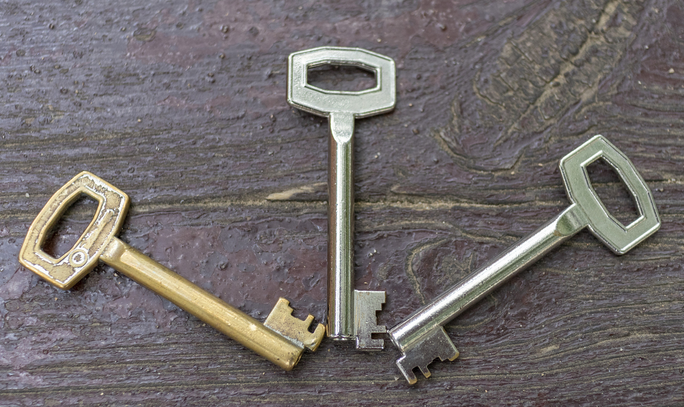 Three antique silver and gold-plated keys