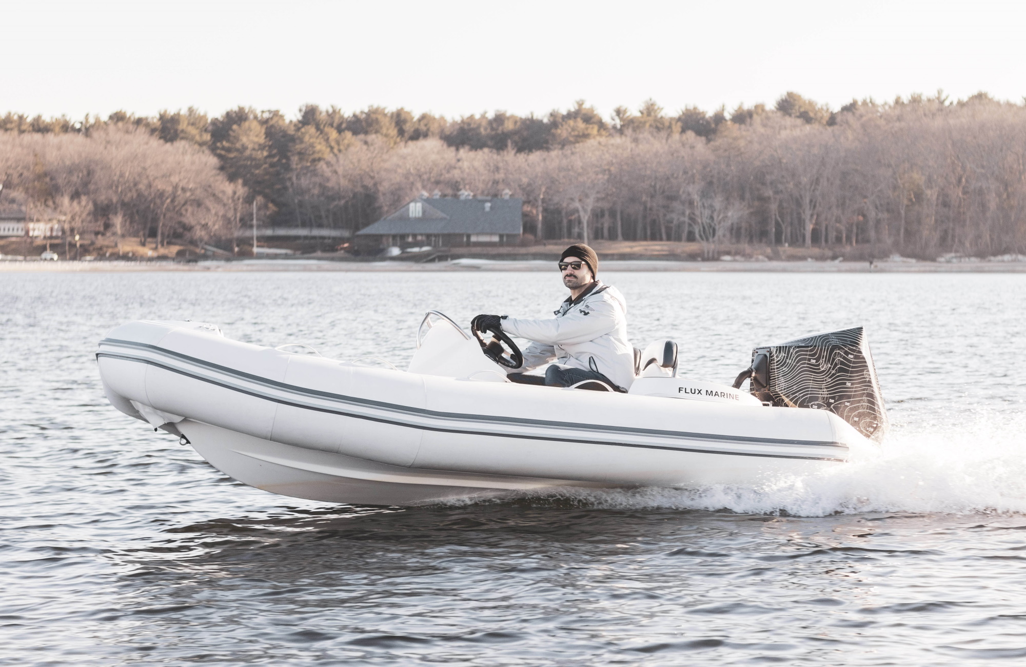 A man drives a dinghy with an electric motor on the back.