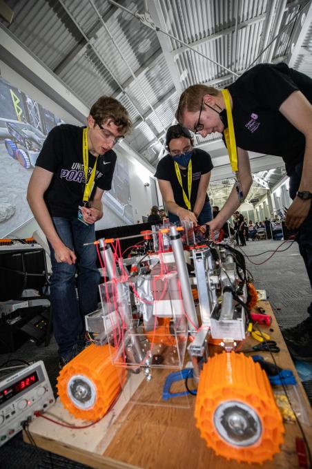 students inspect a lunar mining robot