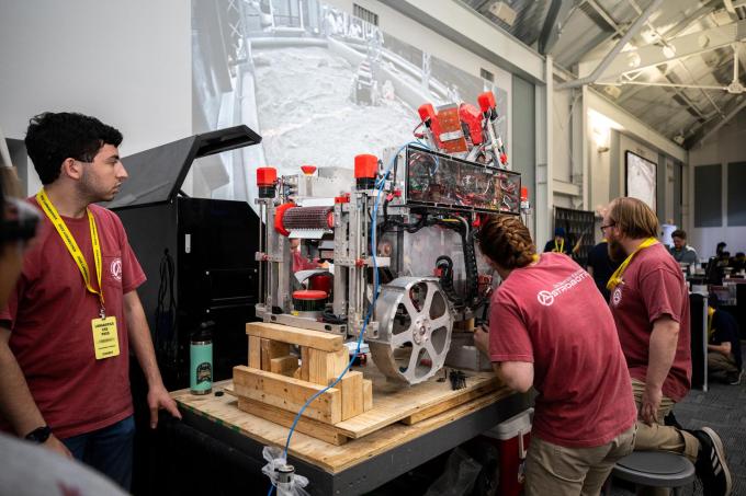 students inspect lunar mining robot