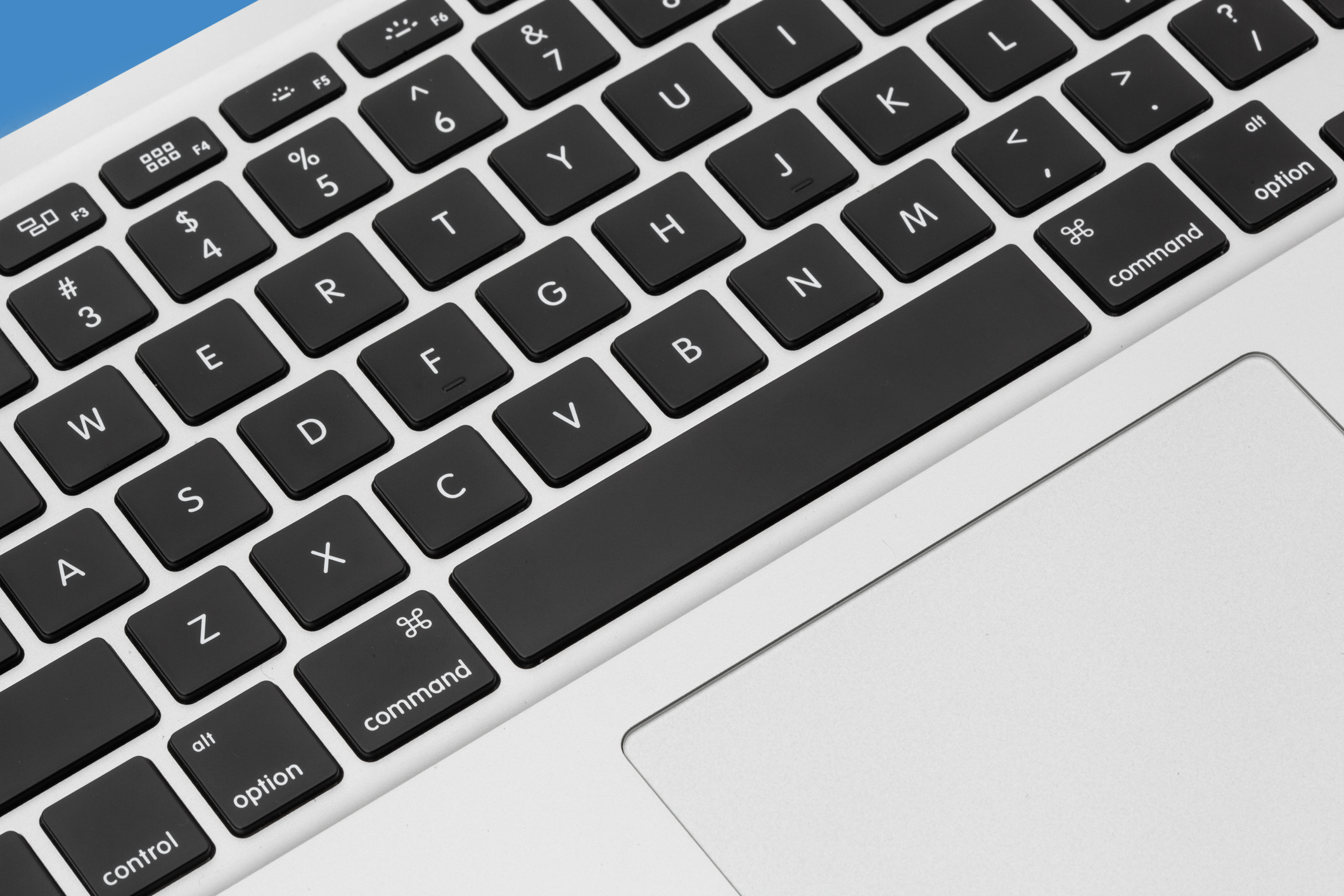 Apple MacBook Pro silver keyboard. close up Mac on the blue background