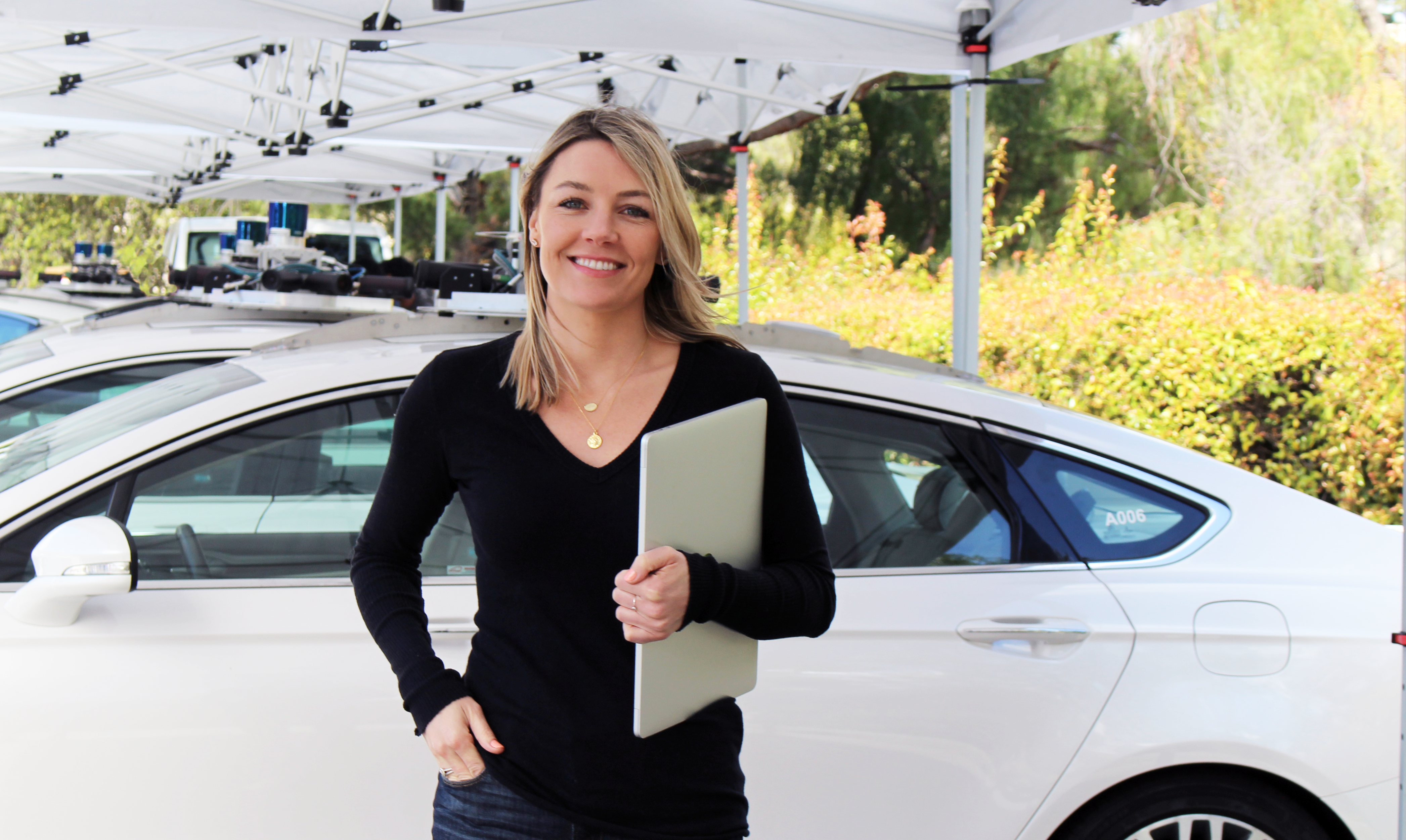 woman with clipboard in front of car